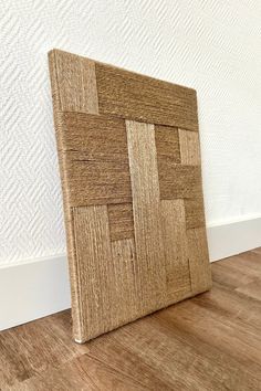 a wooden frame sitting on top of a hard wood floor next to a white wall