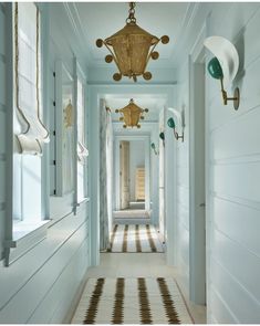 a long hallway with white walls and gold accents