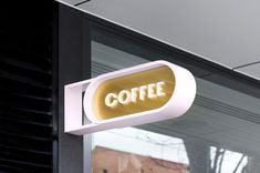 a coffee shop sign hanging from the side of a building