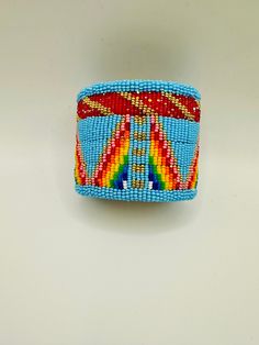 Sky blue and rainbow seed beads. It is 2.5 inches wide and is adjustable to fit any size wrist. It is lined with smoked hide. Made by the owner. Beaded Pouch, Beaded Moccasins, Beaded Cuff, Beaded Bags, Sky Blue, Seed Beads, Blue Sky, Pouch, Cuff