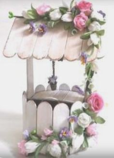 an old fashioned carousel with flowers on the top and bottom, hanging from a chain