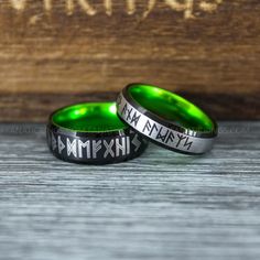 two green and black rings with roman numerals engraved on the inside of them