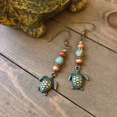 These are 1.5 inches long with brown wood beads, light green river shell beads, gold beads with adorable patina turtles Hippie Beach Earrings For Summer, Handmade Brown Earrings For Beach, Brown Dangling Bead Earrings For Beach, Beaded Turtle Earrings, Boho Earrings Diy, Handmade Shell-shaped Beachy Earrings, Beachy Jewelry, Diy Leather Earrings, Turtle Jewelry