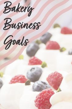 the words bakery business goals written in white frosting with raspberries and blueberries on top