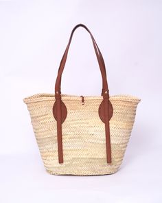 Do you want to look stylish and hippy? Get your hands on this handmade straw bag. It's high quality, eco-friendly, and handcrafted by women in Morocco. Its design is unique and timeless. Get yours now! we are proud to introduce our signature straw french bag to you. it is handmade by our talented artisan who has been working with us for years. this beautiful bag has a unique design that you would find nowhere else. the light and durable material are ideal for taking the bag on your adventures. Style is an important part of your life. The straw bag is a great way to spice up your look. You can either choose from our pre-made designs or customize the bag to your liking. Item's details: *Handmade in Morocco *Material: 100% Woven natural palm straw *Trim: 100% Vegan Leather Dimensions : Height French Basket, French Baskets, Straw Basket, Holiday Bag, Straw Tote, Look Stylish, Leather Handles, Beautiful Bags, Leather Handle