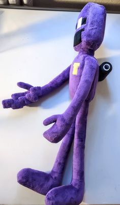 a purple stuffed animal sitting on top of a table