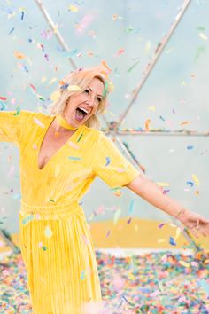 a woman in a yellow dress surrounded by confetti