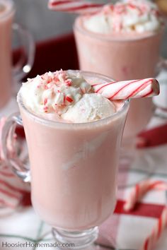 two glasses filled with hot chocolate and candy canes