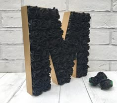 the letter m is made out of black roses