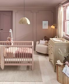 a baby's room with pink walls and furniture