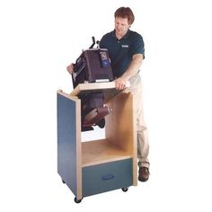 a man standing next to a desk with a computer monitor on top of it,