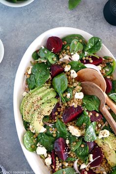 a salad with spinach, beets, avocado and feta cheese