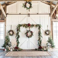 the wedding arch is decorated with greenery and wreaths for an elegant winter ceremony