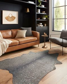 a living room filled with furniture and a rug on top of a hard wood floor