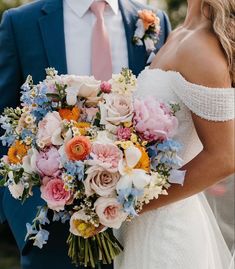 the bride and groom are standing close together holding their wedding bouquets in their hands