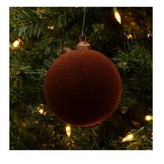 a red ornament hanging from a christmas tree