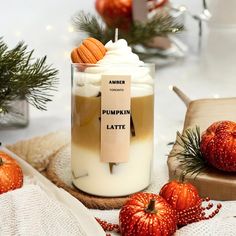 pumpkin latte in a glass surrounded by holiday decorations