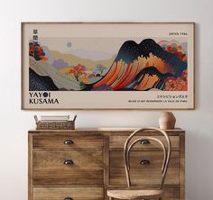 a wooden dresser sitting next to a painting on the wall