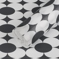 black and white polka dot wrapping paper on top of a tablecloth with circles in the background