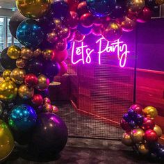 the entrance to a party with balloons and neon lights