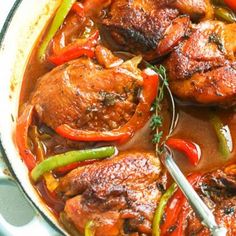 a pan filled with chicken and peppers on top of a table