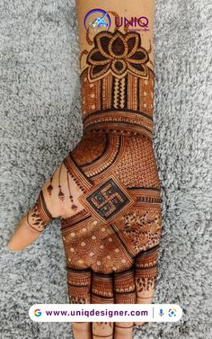 the hand is decorated with henna designs on it and has an intricate flower design