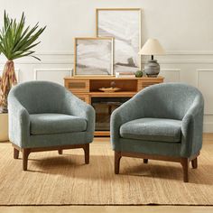 two blue chairs sitting next to each other in a living room