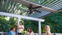 a group of people sitting on top of a white bench under a pergolated roof