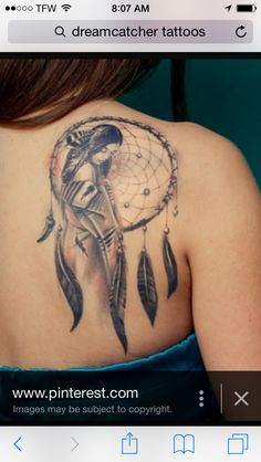 the back of a woman's shoulder with a dream catcher tattoo design on it