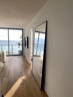 an empty living room with large windows overlooking the ocean