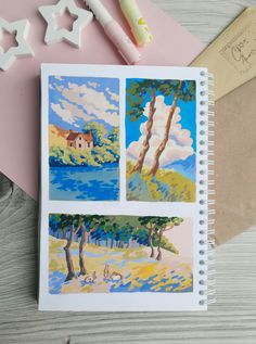 an open notebook with three pictures on it and some crafting supplies next to it