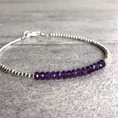 This delicate bracelet features small natural Amethyst gemstones. The faceted Amethyst beads are a beautiful vibrant purple hue. This piece is timeless, yet unique. A perfect gift for a birthday or for your Valentine. The tiny round beads frame the faceted gemstones beautifully. At checkout, choose to buy a Amethyst bracelet with gold or sterling silver beads. * METAPHYSICAL PROPERTIES OF AMETHYST * balance courage peace protection temperance wisdom Free gift with each crystal jewelry purchase f Amethyst Beaded Bracelets With Spacer Beads As Gift, Everyday Purple Hand-strung Jewelry, Amethyst Beaded Bracelet, Diamond Carat Size, Shiny Bracelets, Amethyst Bracelet Beads, Mini Bracelet, Diamond Bracelet Design, Classic Bracelets