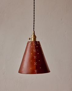 a brown lamp hanging from a ceiling in front of a white wall with stars on it