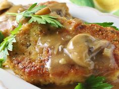 meat with mushroom gravy on a white plate