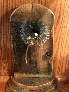 an old wooden box with a wreath on top and other decorations hanging from the front