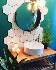 a bathroom with a sink, mirror and potted plants