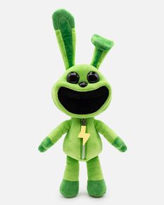 a green stuffed animal with big eyes and a yellow lightning bolt on it's chest