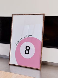 a pink and white pool ball with the number eight written on it in front of a fireplace