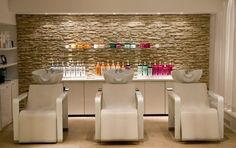 a room with several chairs and bottles on the wall behind them in front of a counter