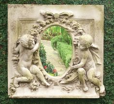 an image of two cherubs in a mirror on the side of a wall