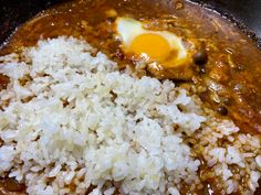 rice and an egg are being cooked in a skillet