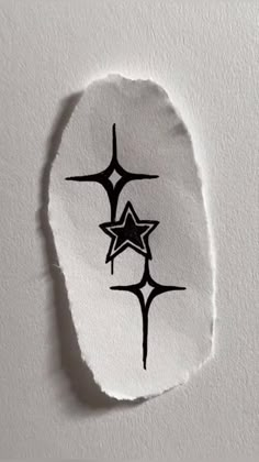 a piece of white paper with black ink on it that has three stars in the middle