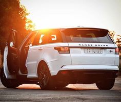 the white range rover is parked on the side of the road