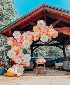 an outdoor gazebo decorated with balloons and flowers