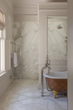 a marble bathroom with a claw foot tub