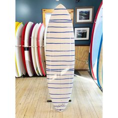 a surfboard is standing up against the wall in a room full of surfboards