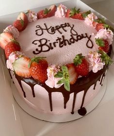 a birthday cake decorated with strawberries and flowers