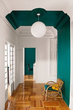 an empty room with green walls and wooden floors