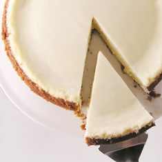 a white cake sitting on top of a plate with a slice cut out of it