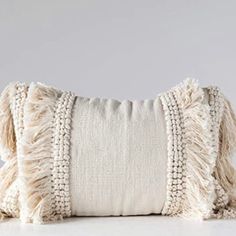 a white pillow with fringes on it